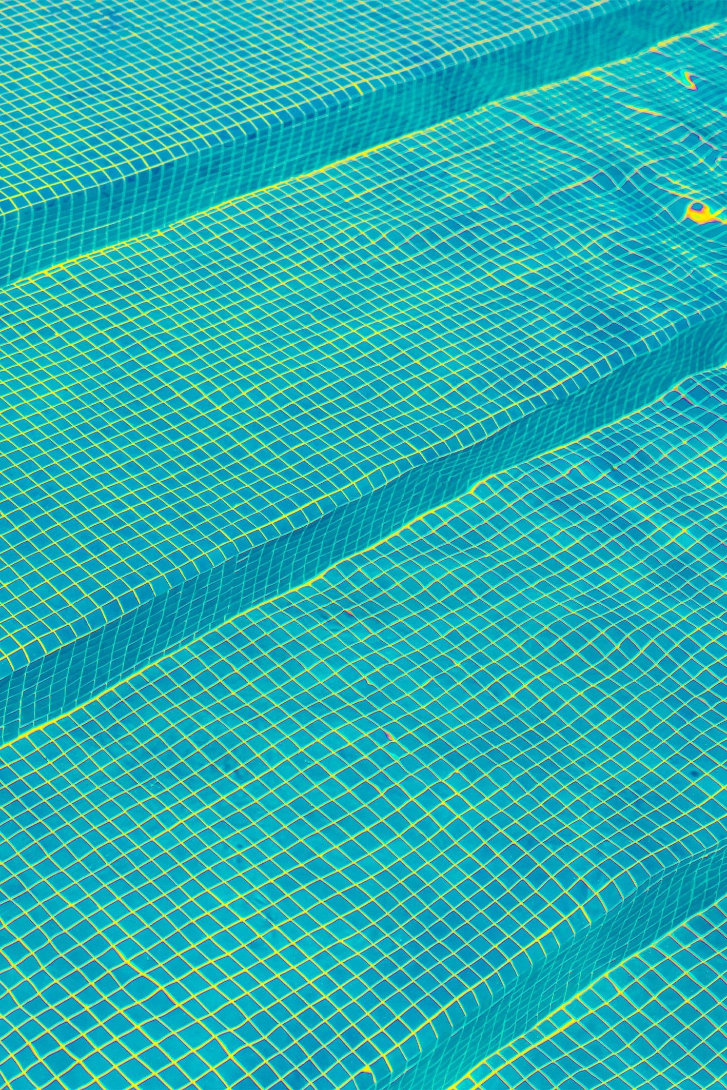 A moment of calm in a busy swimming pool, with a typical mosaic of aquatic blue - a pattern that instinctively makes you wanna dive right in. A fine art photography print by Will Bremridge, available to purchase exclusively on The Lost Works.