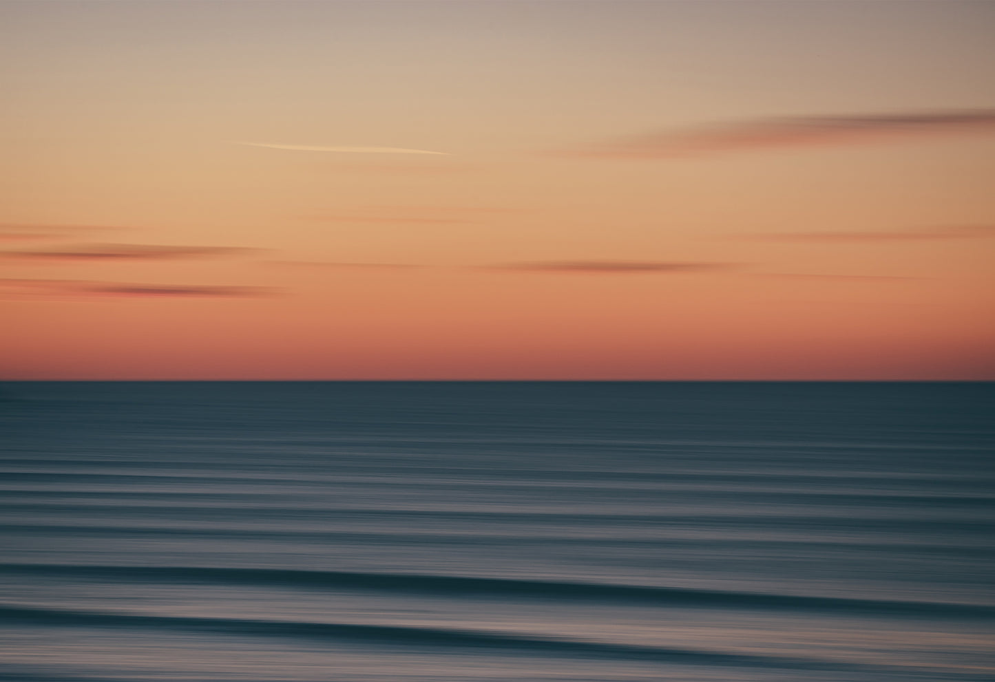 Abstract long-exposure photograph of a sunset over the ocean at Fistral Beach, Newquay, a seascape print with soft pastel tones and blurred waves.