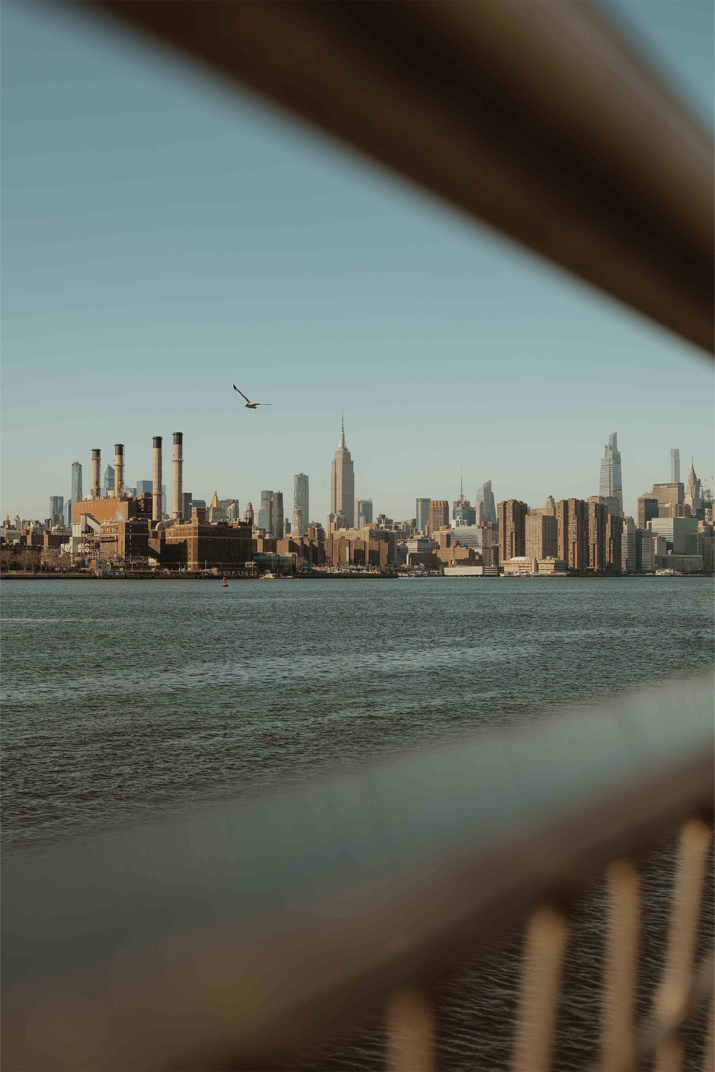 A fine art print by Hannes Kläger, showing the New York City skyline shot from across the river in Brooklyn. Available to purchase with free framing from The Lost Works gallery.