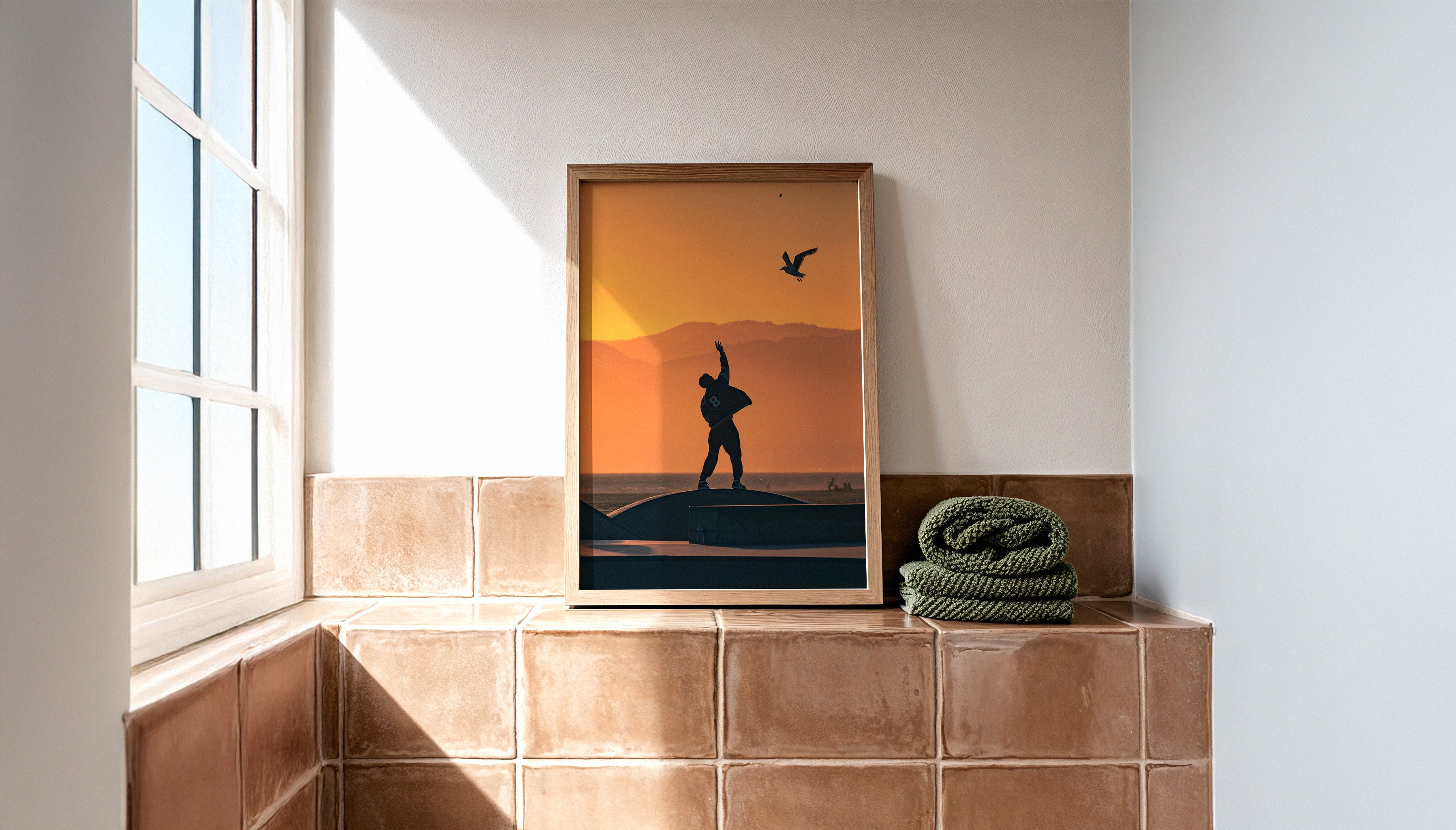Modern bathroom with natural light and ceramic tiles showcasing “BREADCRUMB,” a framed sunset photography print by Craig Hubbard - perfect for cozy, earthy interior design aesthetics.