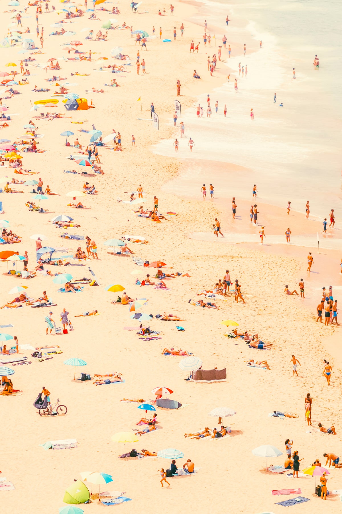 A busy summer's day In Ericera. Get lost in a typical beach scene, with sun bathers, parasols, surf boards and water frolicking. A fine art photography print by Will Bremridge, available to purchase on The Lost Works.