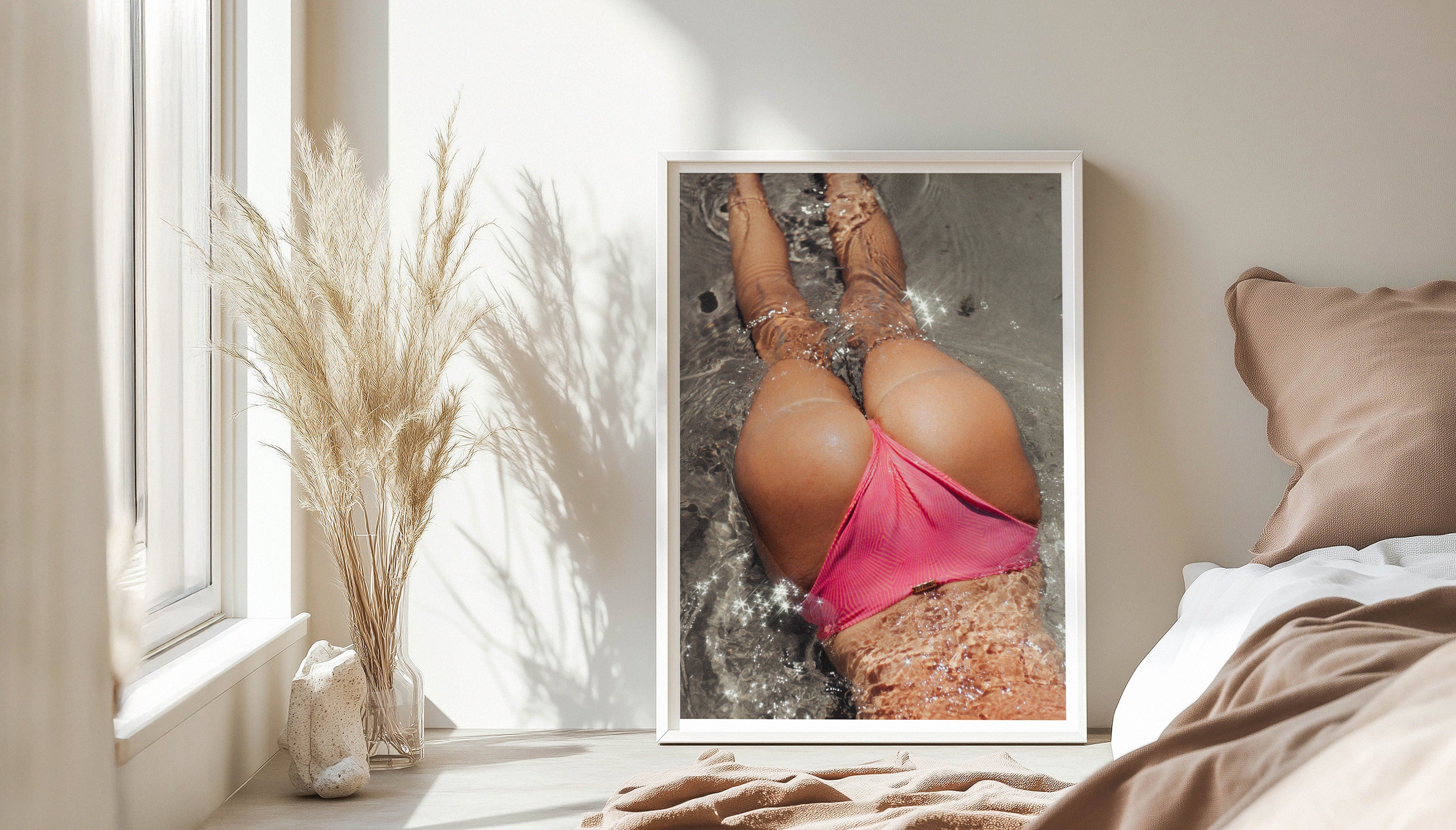 CHEEKY by Evie Johnstone, a fun ready-to-hang photography print with hot pink accents in a large white frame leaning against a white wall next to a window with pampas grass in a glass vase.
