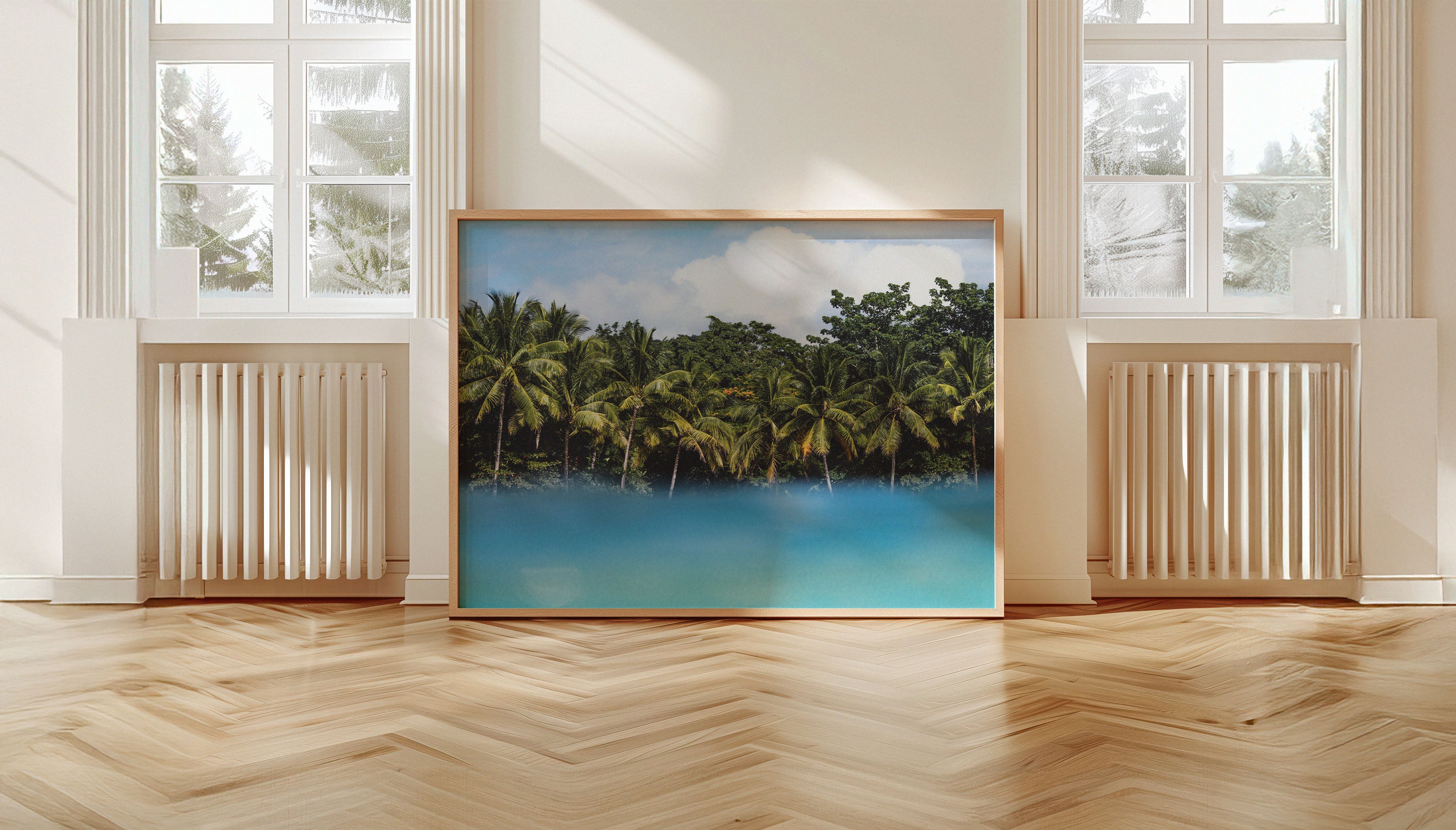 Framed tropical coastal wall art titled FLOATING PALMS by Ez Rivero displayed in a sunlit contemporary room with wood flooring.