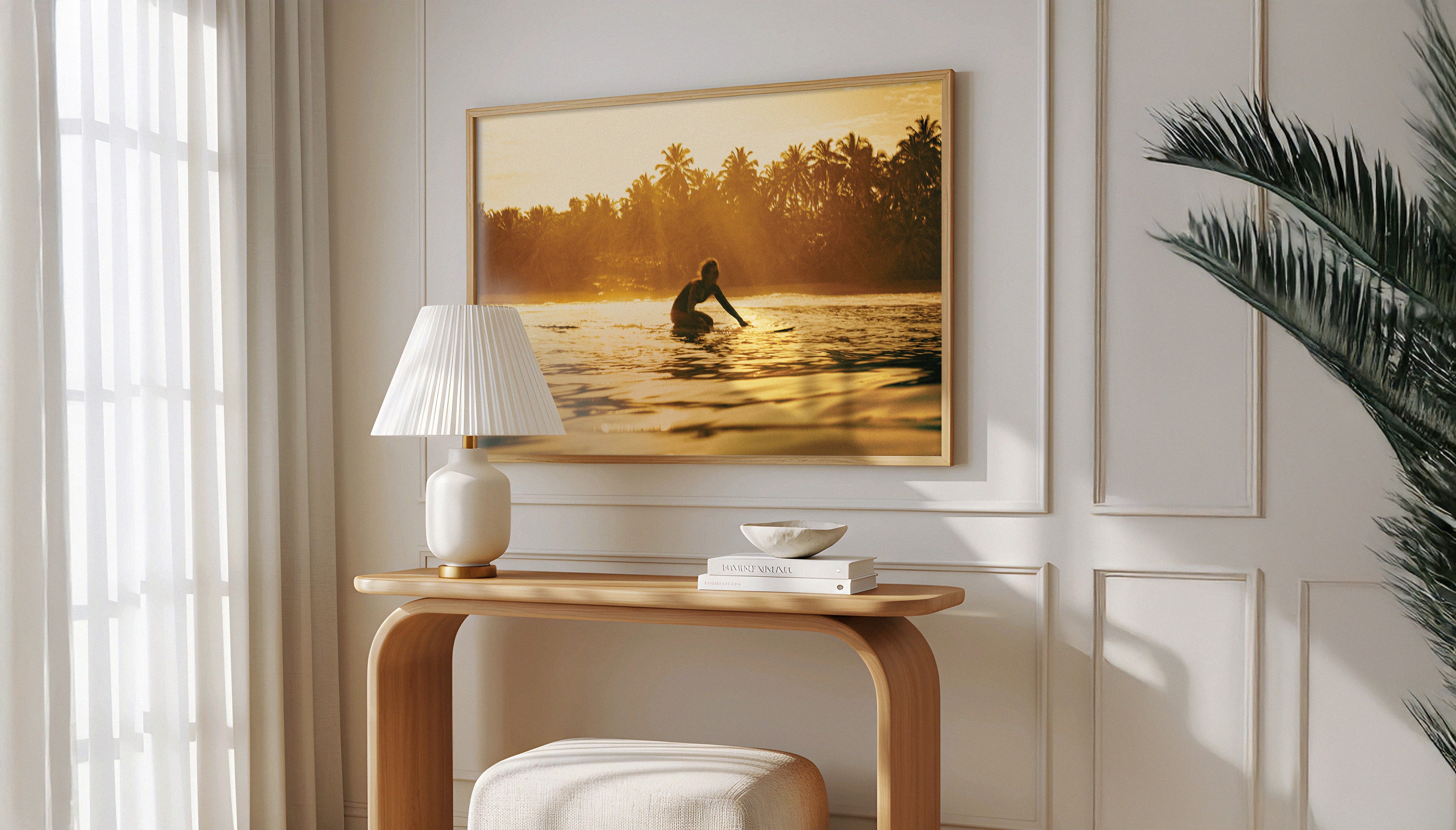 Framed travel photography print of surfer at sunset by Ez Rivero styled in a modern living room. Natural light and tropical plant decor.