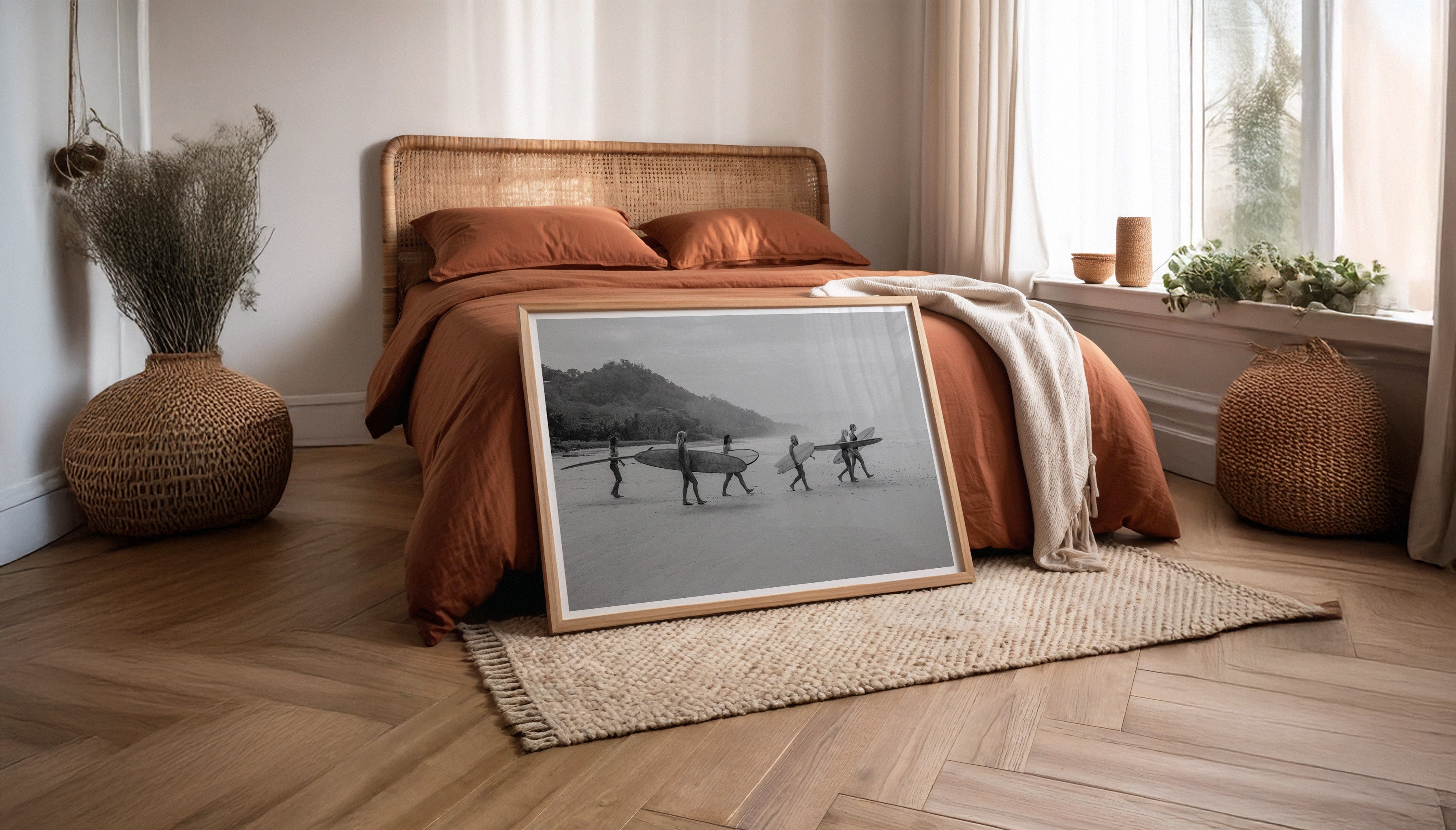 Evie Johnstone's GONE SURFING photography print in a natural styled bedroom, leaning against a bed in large wooden frame.