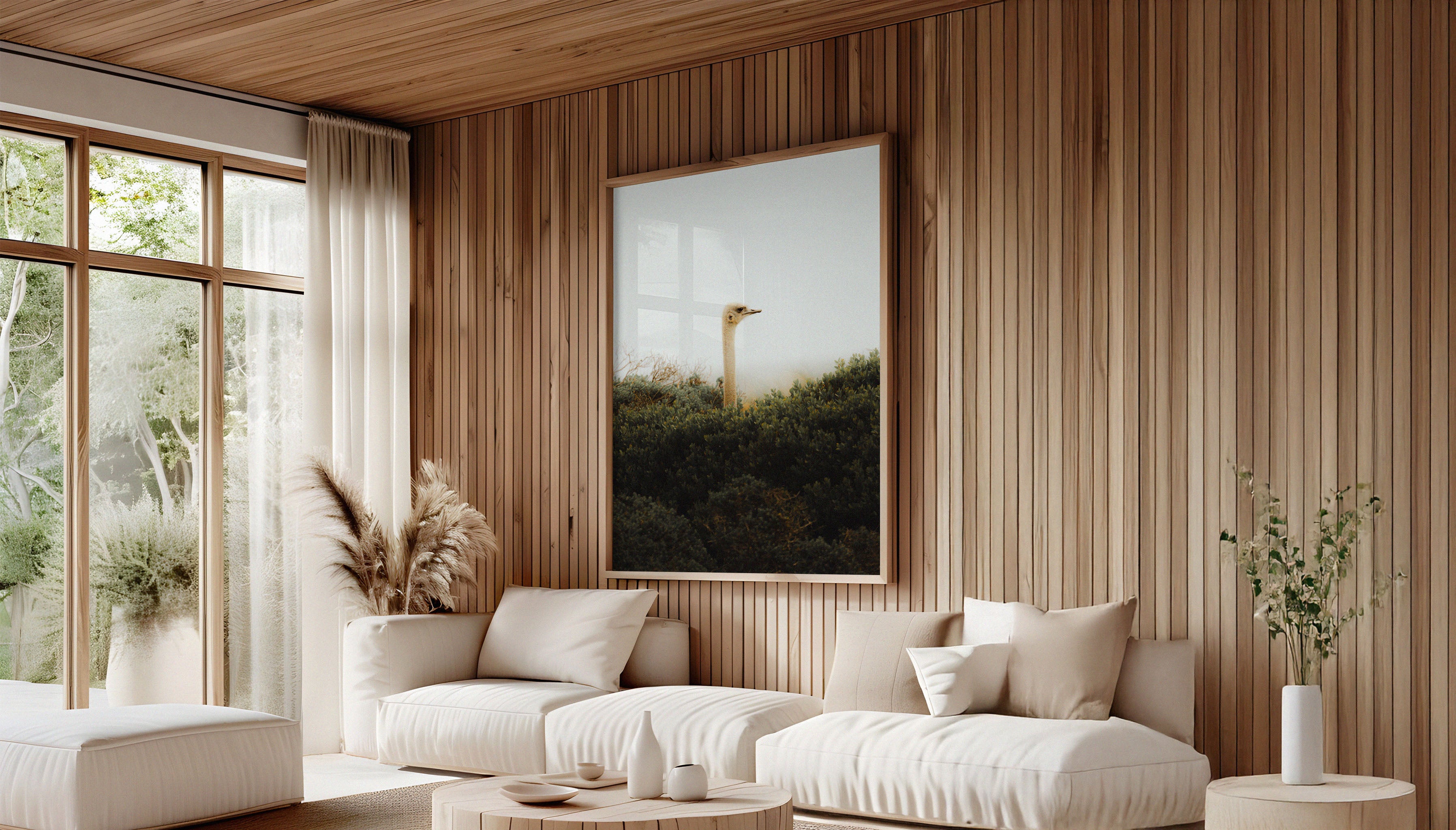 Evie Johstone's LOST OSTRICH photography fine art print in a large wooden frame hanging on a wood panelled wall in a Scandi-style interior with plants and a cream sofa.