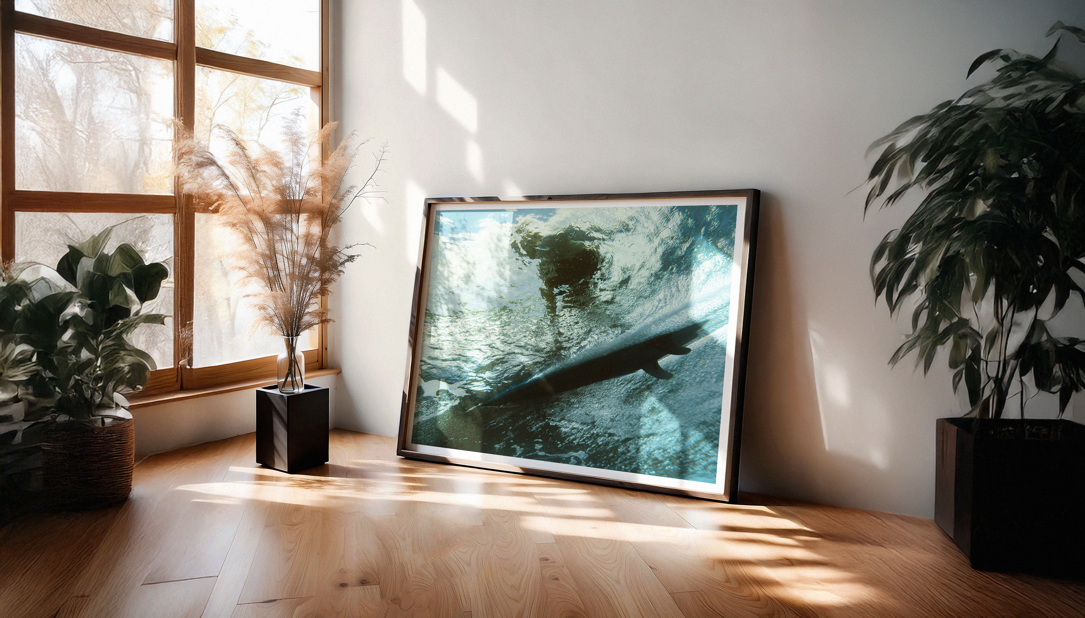 "PERSPECTIVE" by surf photographer Ez Rivero displayed in a black frame with a white border, leaning against a wall in a contemporary living space.