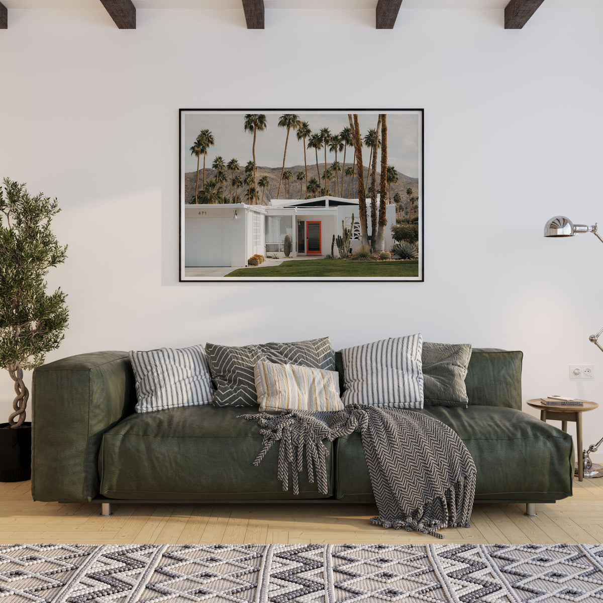 Green sofa in a living room with a large framed picture of a Palm Spring and palm trees on the wall. Fine art photo print by Hannes Klager.