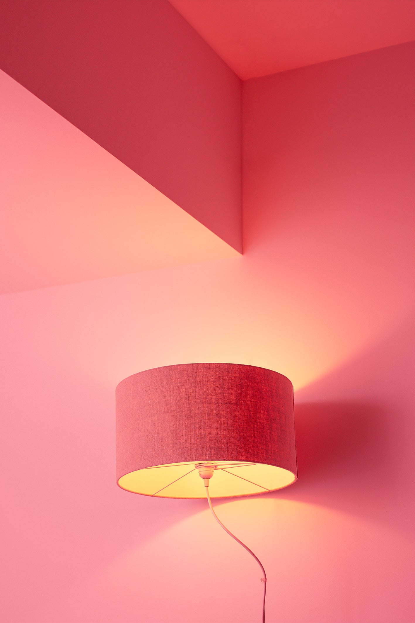 A hotel in Sagres bathes its guests in a feel-good pink glow, with a bright pink wall and matching bright pink lamp. A piece of wall art that will brighten up any room. Photography print by Will Bremridge.
