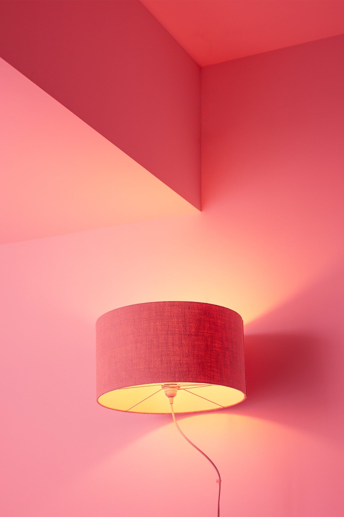 A hotel in Sagres bathes its guests in a feel-good pink glow, with a bright pink wall and matching bright pink lamp. A piece of wall art that will brighten up any room. Photography print by Will Bremridge.