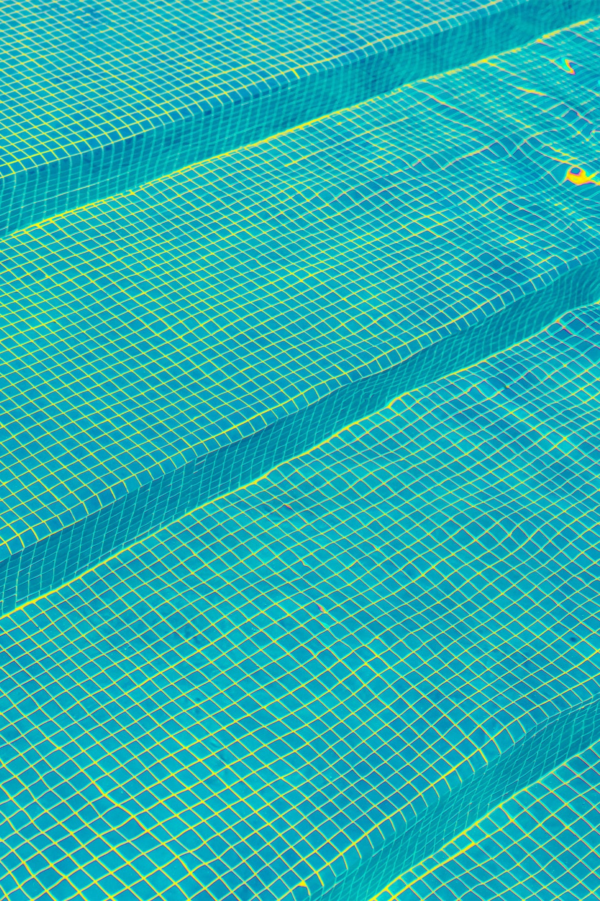 A moment of calm in a busy swimming pool, with a typical mosaic of aquatic blue - a pattern that instinctively makes you wanna dive right in. A fine art photography print by Will Bremridge, available to purchase exclusively on The Lost Works.