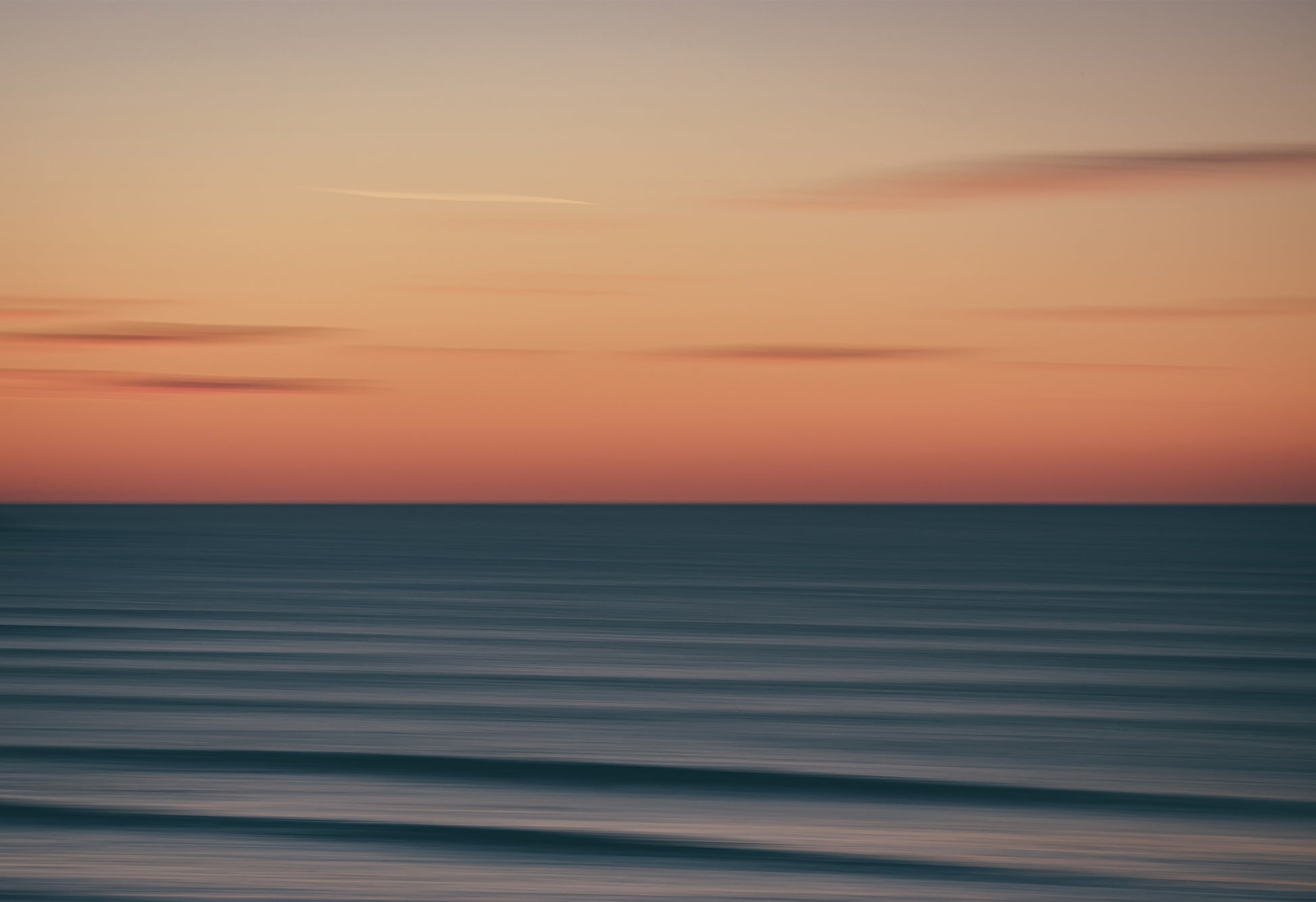 Abstract long-exposure photograph of a sunset over the ocean at Fistral Beach, Newquay, a seascape print with soft pastel tones and blurred waves.