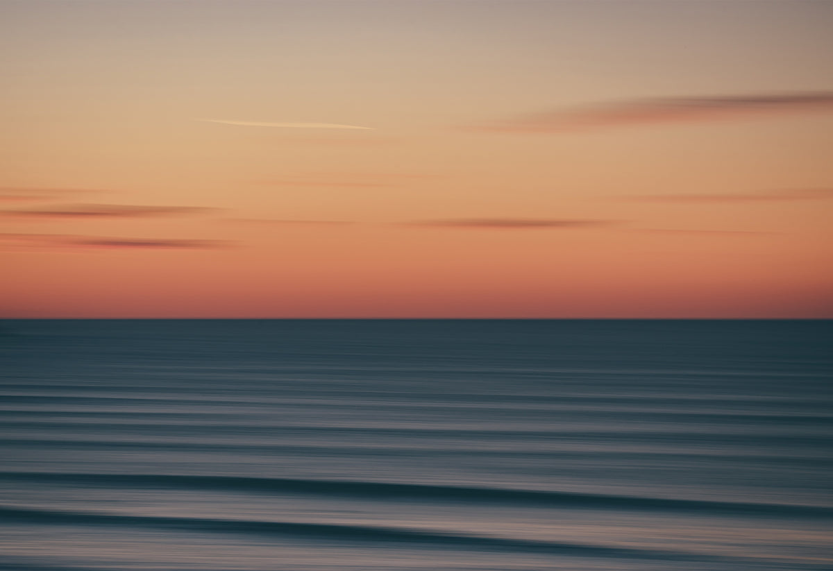 Abstract long-exposure photograph of a sunset over the ocean at Fistral Beach, Newquay, a seascape print with soft pastel tones and blurred waves.
