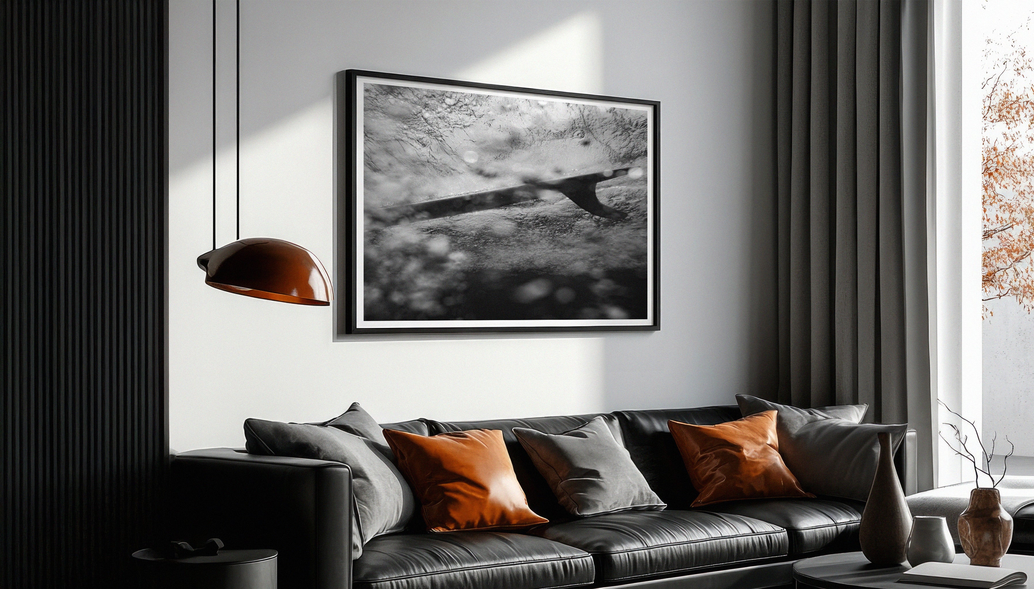 "SUBMERGED" by Ez Rivero displayed in a living room - framed black and white surf print adding a minimalist coastal vibe to interior design.