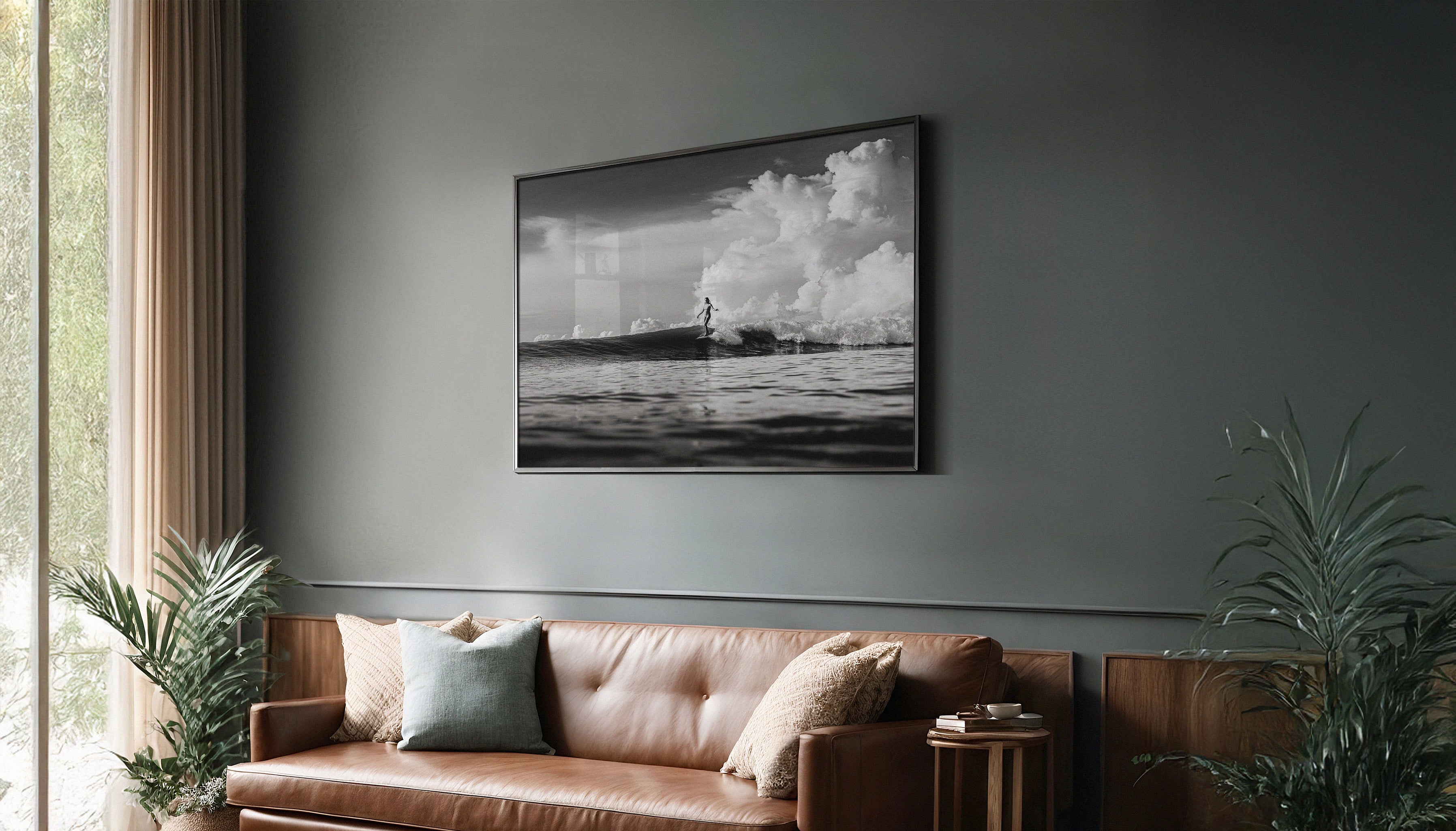 Modern living room with a large fine art surf photograph by Ez Rivero above a leather couch, integrating travel photography with interior decor.