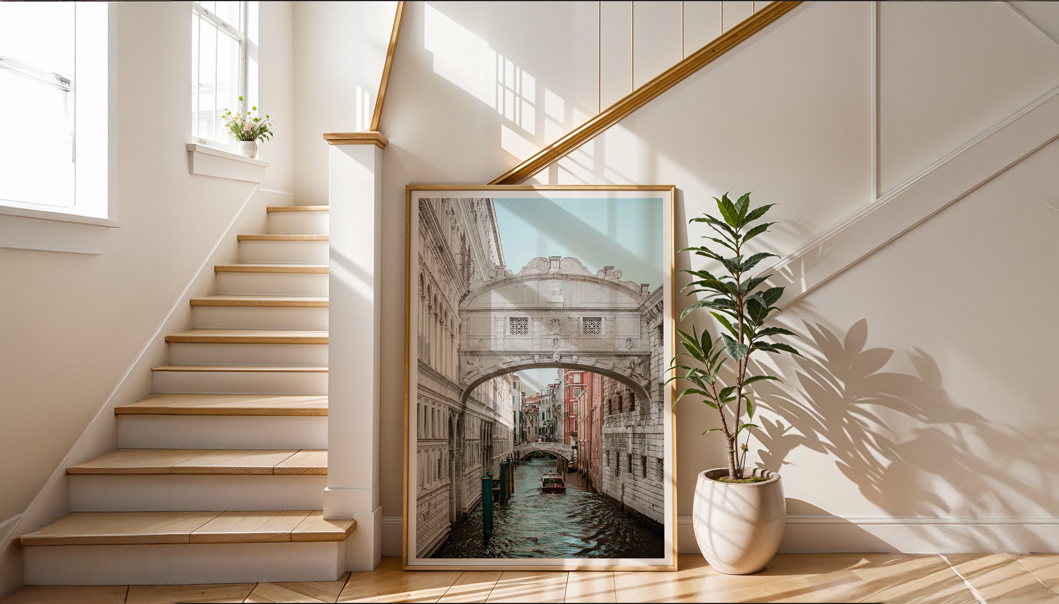 A large print of Charles Johnstone's stunning pastel photograph of the Bridge of Sighs in Venice, in a wooden frame leaning against a Scandi-style staircase.